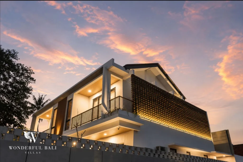 The two-storey villa lit up at sunset showing the glowing woven-brick balcony screen at a 4-bedroom villa in Pererenan, Bali