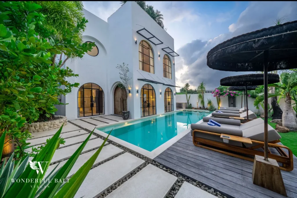 Villa and lit pool at dusk at a 4-bedroom villa in Canggu Bali