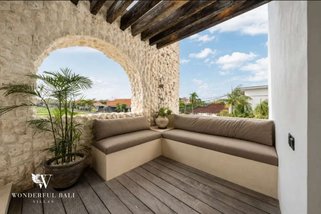 Upper terrace seating in a coral stone arch overlooking rice fields at a 4-bedroom villa in Canggu Bali