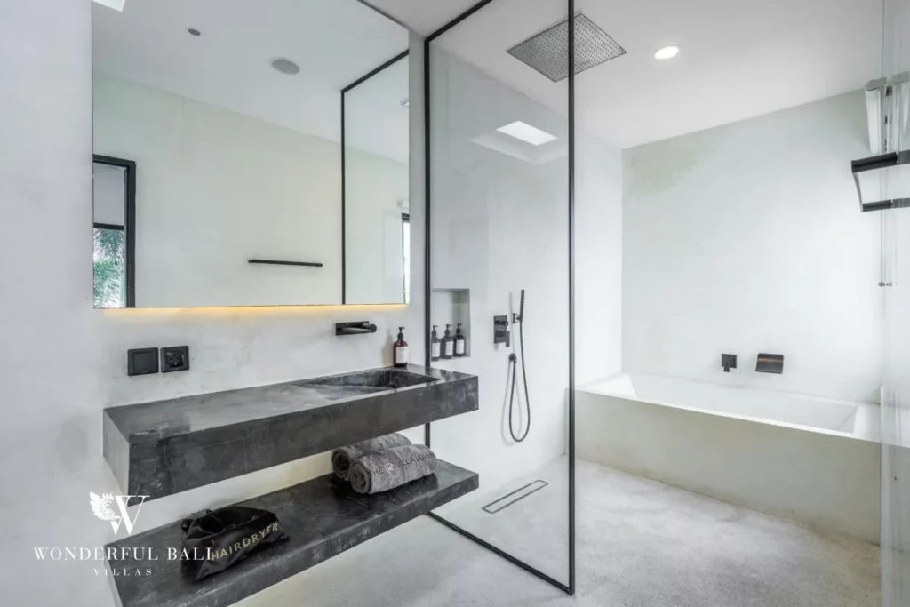 En-suite bathroom with a stone vanity, rainfall walk-in shower and built-in bathtub at a 5-bedroom villa in Pererenan, Bali