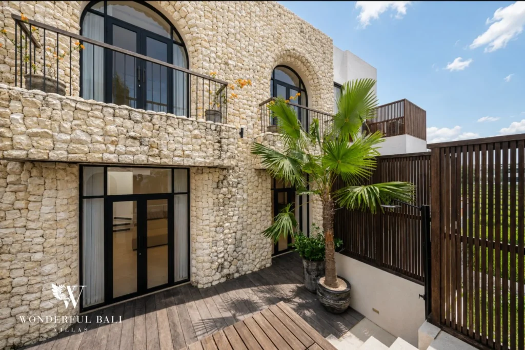 Coral stone facade with arched balconies beside rice fields at a 4-bedroom villa in Canggu Bali