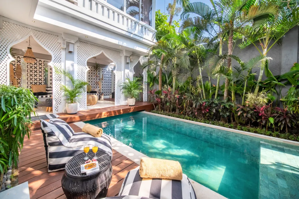 Villa Moana, Canggu — pool, deck at Villa Moana with striped daybeds, drinks table and arched lattice screens