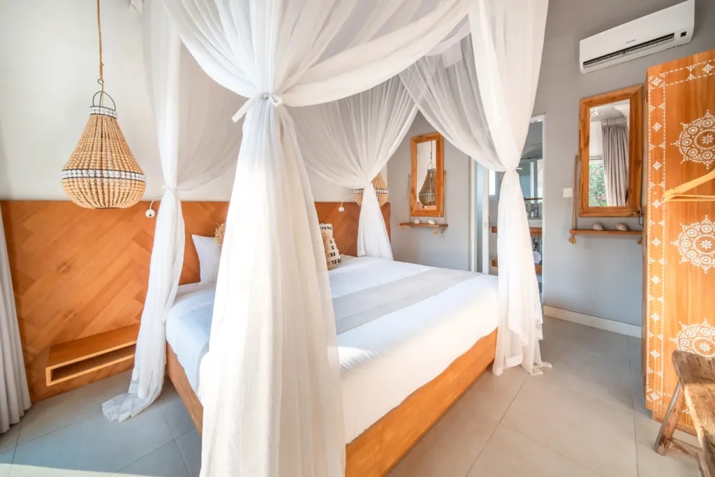 Villa Moana, Canggu — bedroom, villa Moana with carved white doors and beaded pendant light