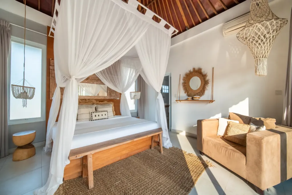 Villa Moana, Canggu — bedroom, king bedroom at Villa Moana beneath an exposed timber ceiling with a seating corner