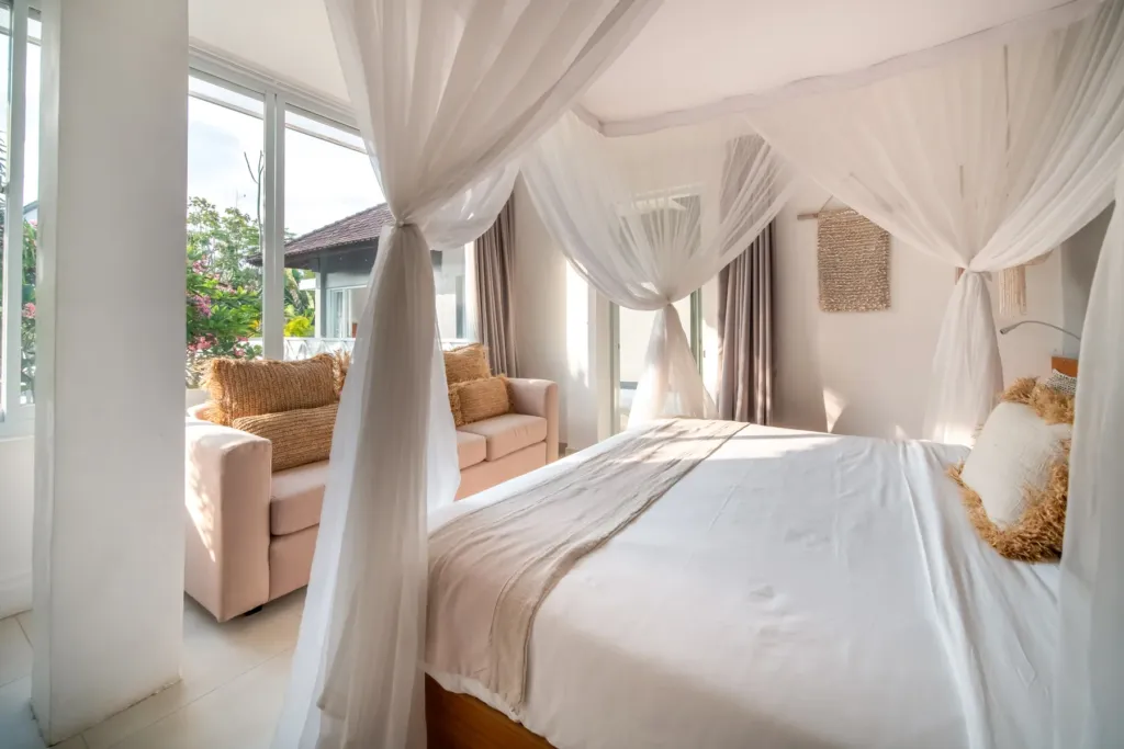 Villa Moana, Canggu — bedroom, canopy bed and sofa in a light-filled bedroom at Villa Moana, Canggu