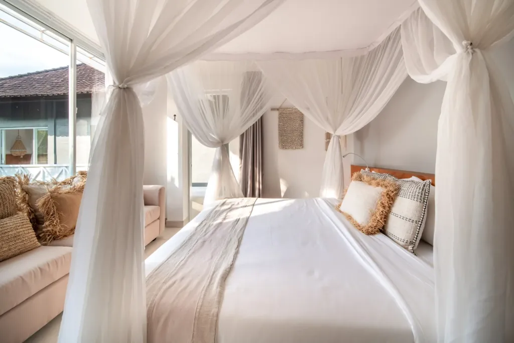Villa Moana, Canggu — bedroom, king bed with mosquito net canopy and daybed seating at Villa Moana