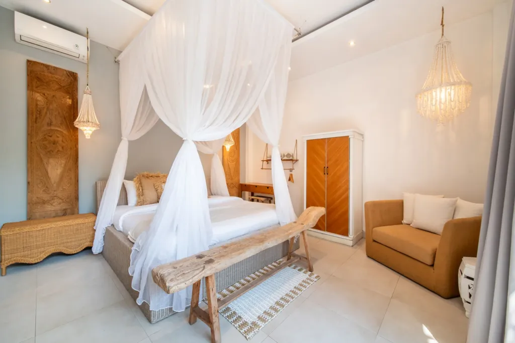 Villa Moana, Canggu — bedroom, king bedroom at Villa Moana with carved timber door and beaded chandelier