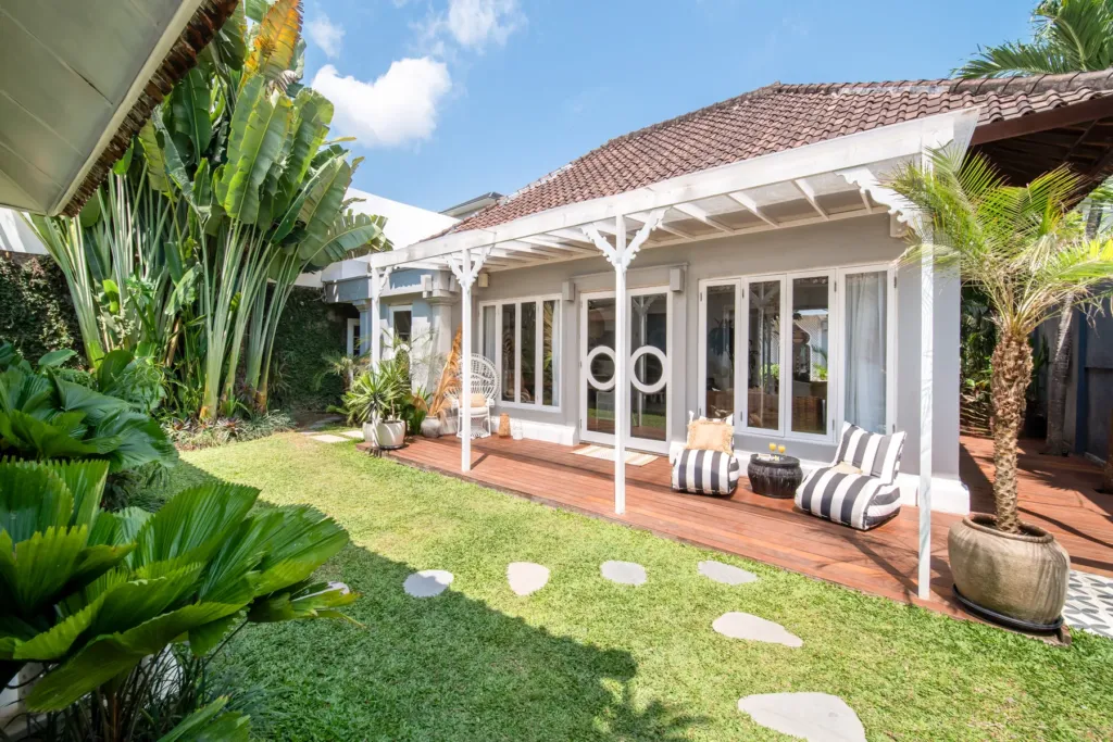 Villa Moana, Canggu — garden, lawn and covered terrace with striped daybeds in Villa Moana's garden