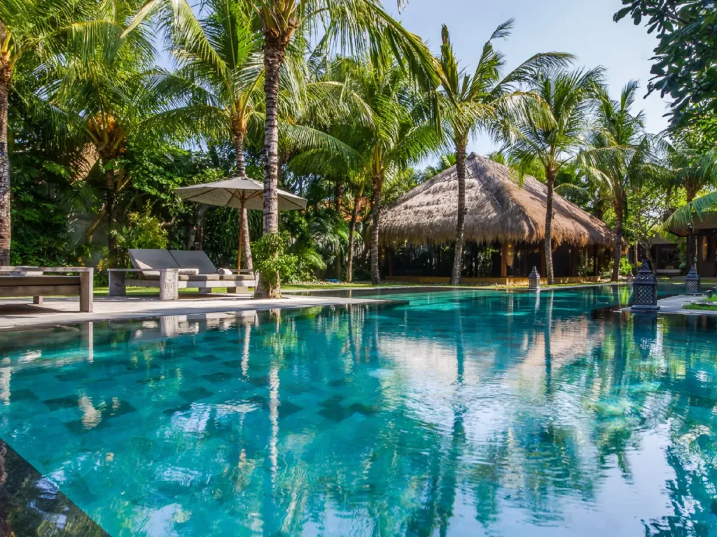 Sun loungers and parasols along the pool at Villa Yoga, Seminyak