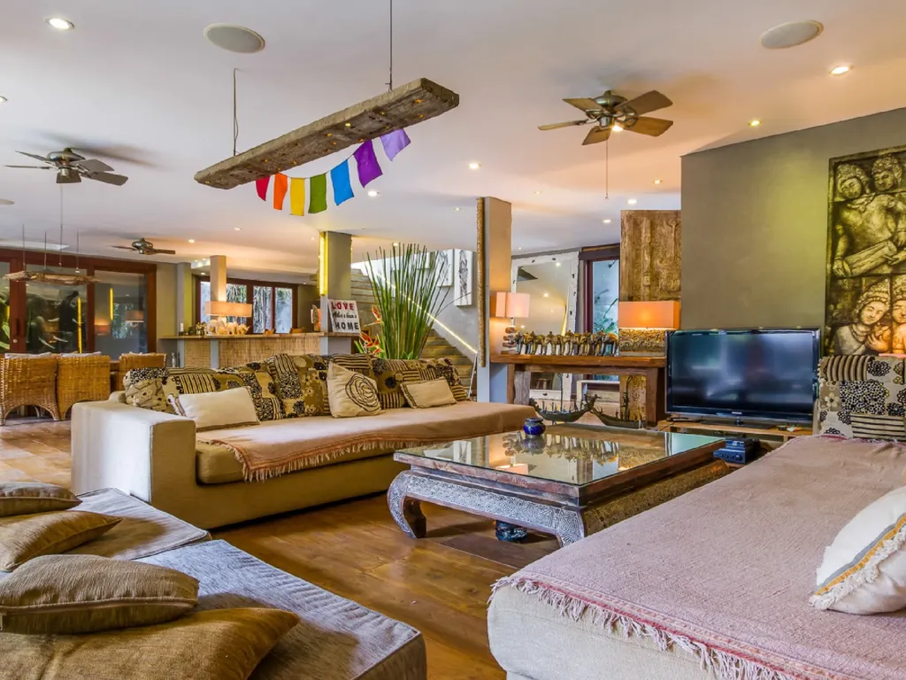 Open-plan living pavilion at Villa Yoga with teak floors and deep sofas