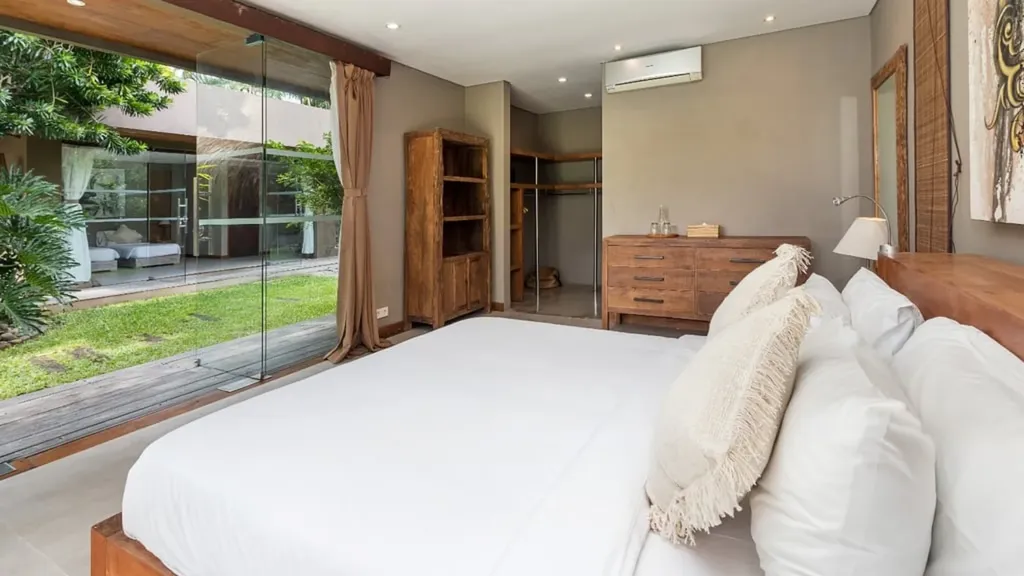 Bedroom 6 at Villa Yoga with sliding glass doors to the pool garden