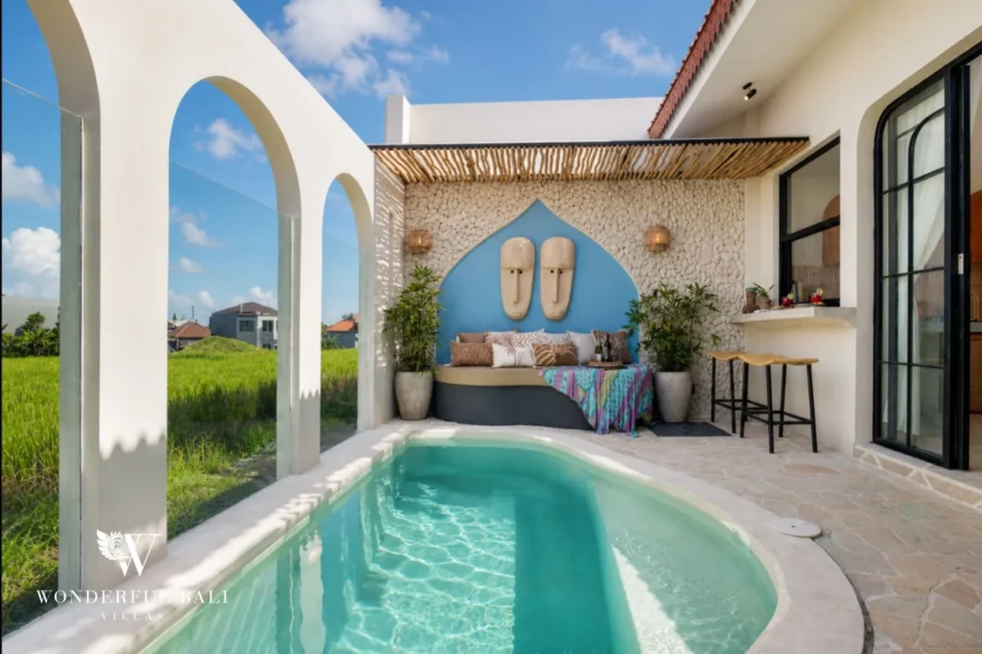 Curved pool with white arches framing rice fields at a 2-bedroom villa in Buduk Canggu Bali