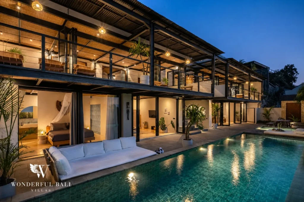 Two-storey steel and rattan villa lit above the pool at dusk in Uluwatu Bali