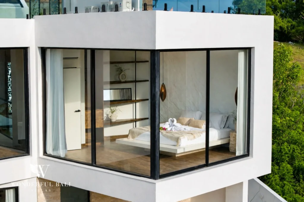 White villa with a full-height glazed corner bedroom above the garden at a 3-bedroom villa near Nusa Dua Bali
