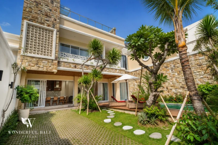 Three-storey stone-clad villa above a lawn and pool in Tumbak Bayuh Pererenan Bali