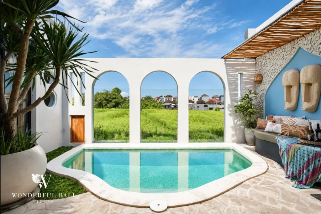 Three white arches framing open rice paddy beside the pool of a 2-bedroom villa in Buduk Canggu Bali