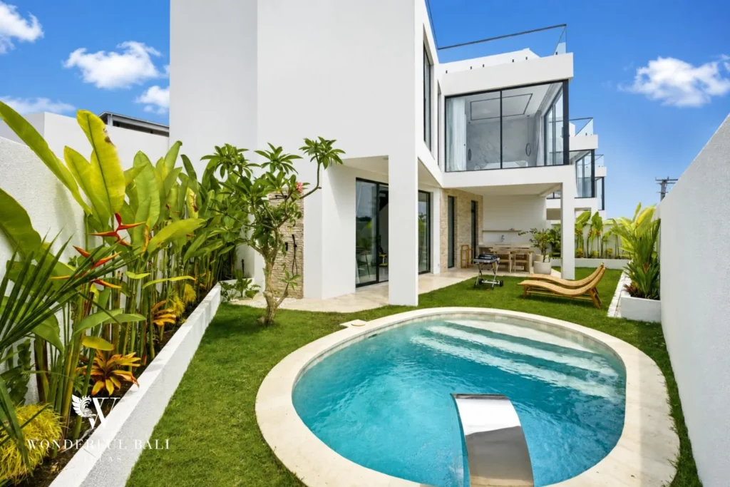 Round private pool and lawn beside a white three-storey villa near Nusa Dua Bali