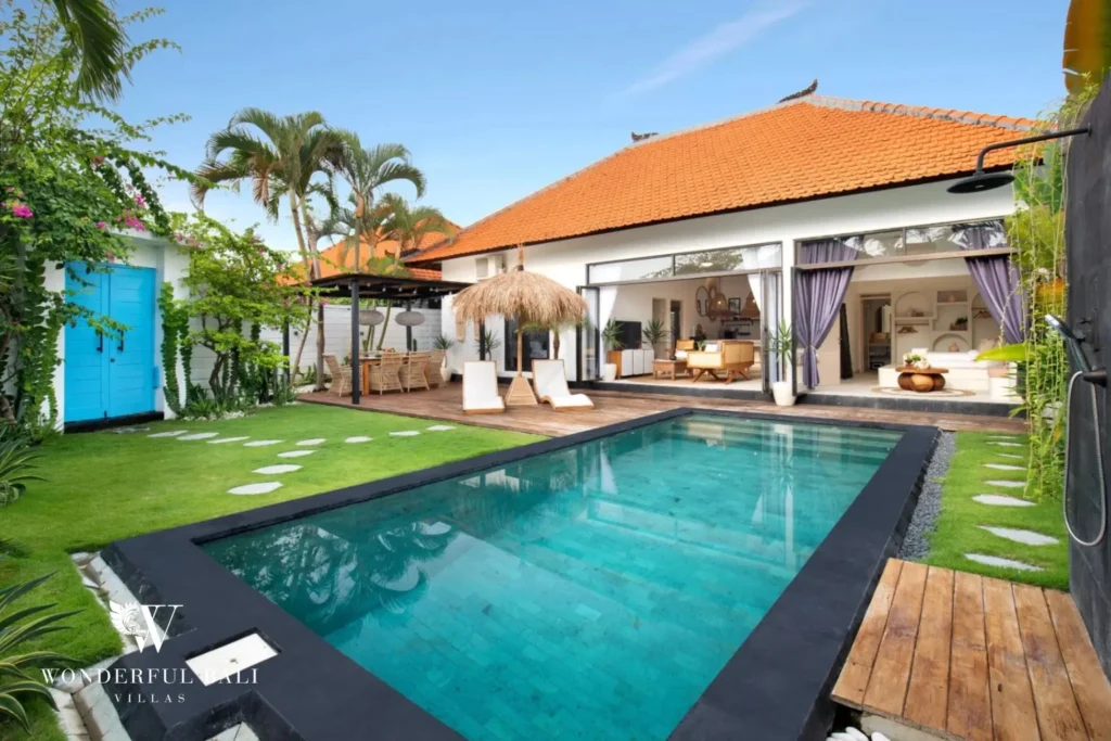 Lap pool framed by palms and a blue timber gate at a 3-bedroom villa in Umalas Bali