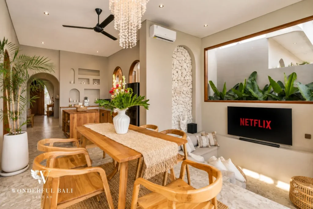 Living and dining room with arched niches and a smart TV in a 2-bedroom villa in Pererenan Bali