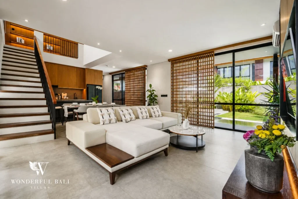 Double-height living room with floating timber stair in a 3-bedroom villa in Jimbaran Bali