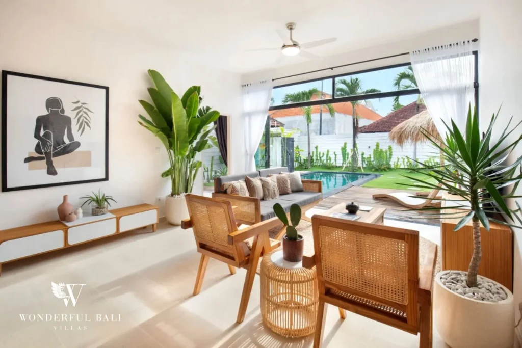 Living room with rattan seating opening to the pool in a 3-bedroom villa in Umalas Bali