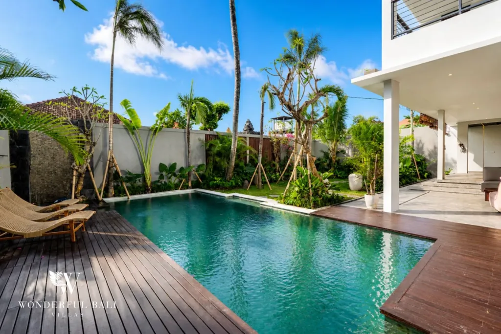 4BR villa for rent in Seminyak — pool, timber pool deck with sun loungers under the palms