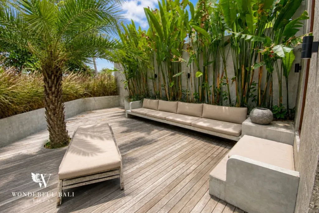 3BR villa for rent in Kedungu — terrace, timber deck with an outdoor sofa under a palm