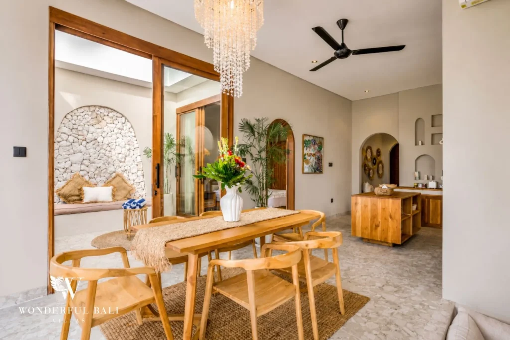Teak dining table beside the open kitchen in a 2-bedroom villa in Pererenan Bali