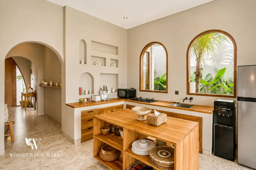 Teak kitchen island with open shelving and arched niches in a 2-bedroom villa in Pererenan Bali