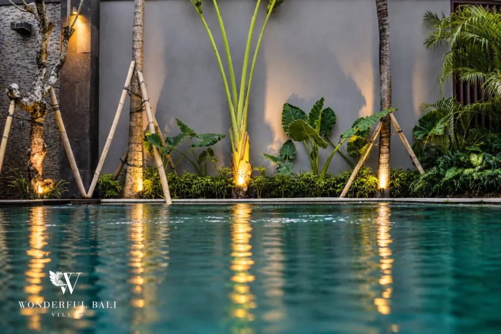 4BR villa for rent in Seminyak — pool, planted wall reflected in the lit pool