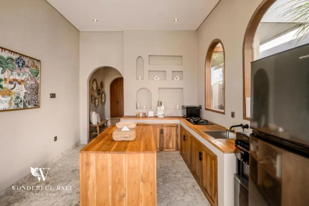 Teak kitchen with built-in oven and full-height fridge in a 2-bedroom villa in Pererenan Bali