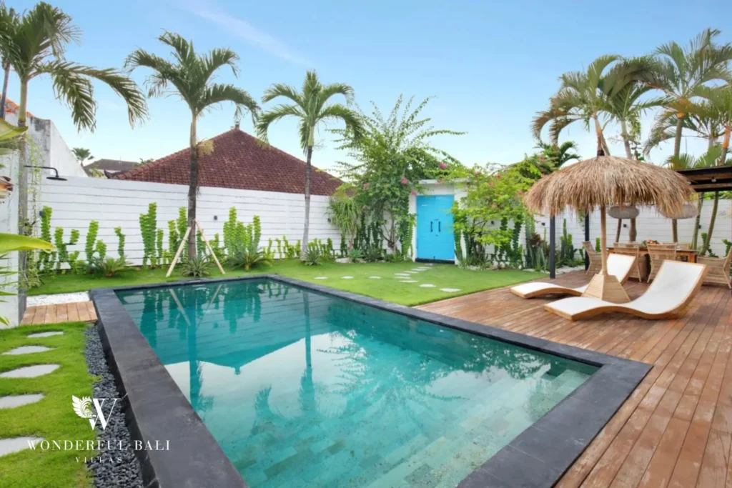 Black-tiled lap pool and lawn at a 3-bedroom villa in Umalas Bali