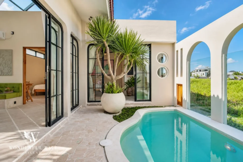 Flagstone pool terrace with dragon tree and arched doors in a 2-bedroom villa in Buduk Canggu Bali