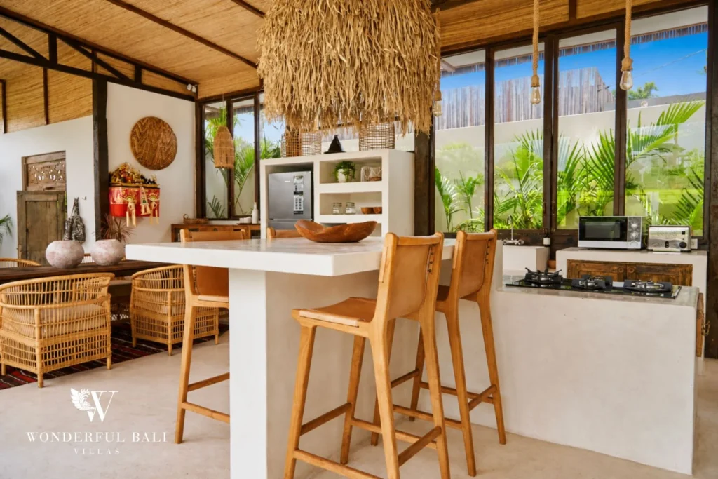 Open kitchen with a white counter, bar stools and gas hob at a 3-bedroom villa in Umalas Bali