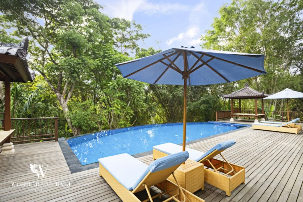 Sun loungers and parasols on the timber pool deck at a 3-bedroom villa in Kaba-Kaba Bali