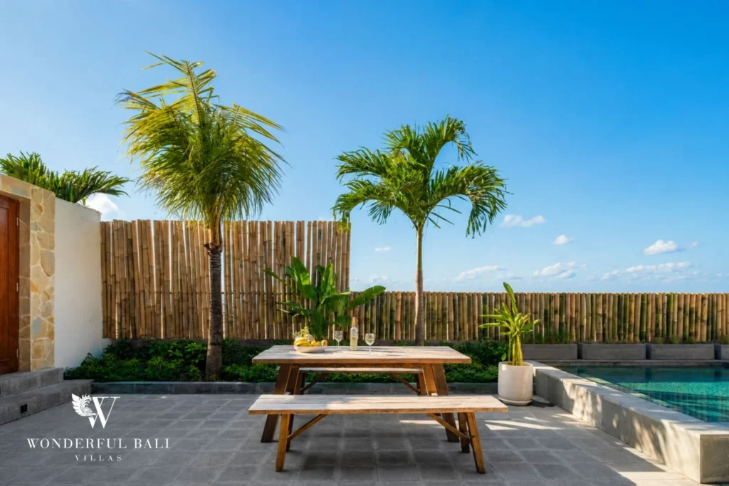 Picnic table and palms beside the pool at a 5-bedroom villa in Uluwatu Bali