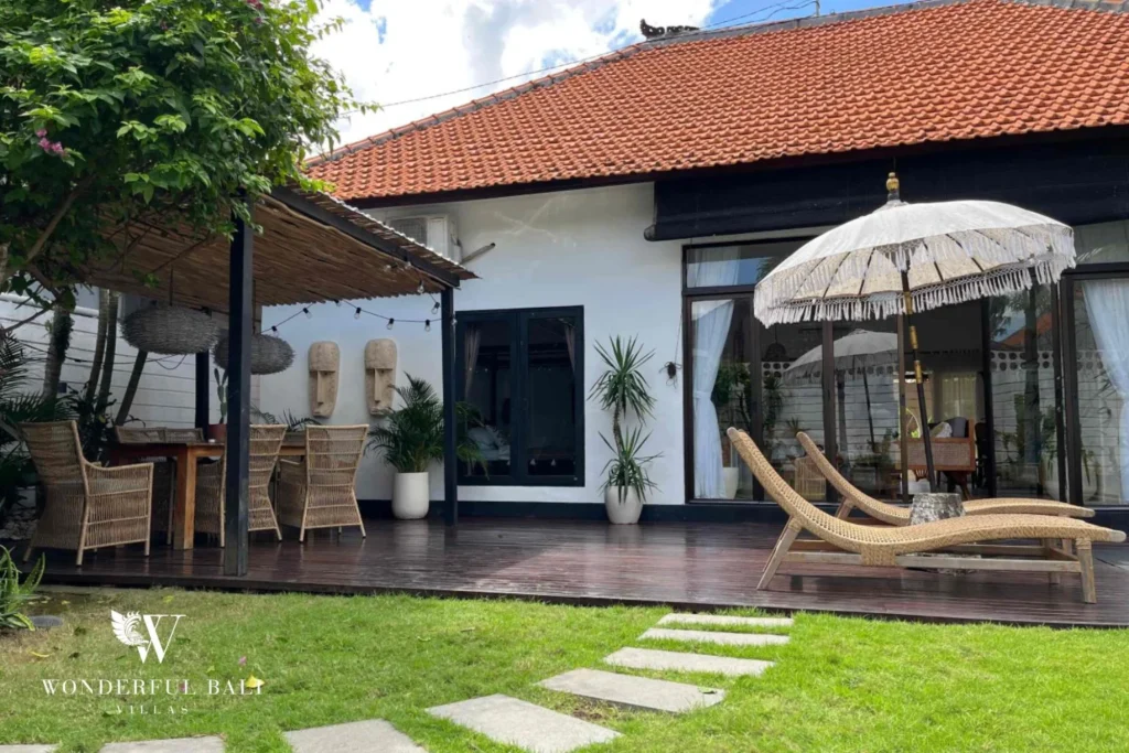 Villa terrace with carved masks and pergola dining at a 3-bedroom villa in Umalas Bali