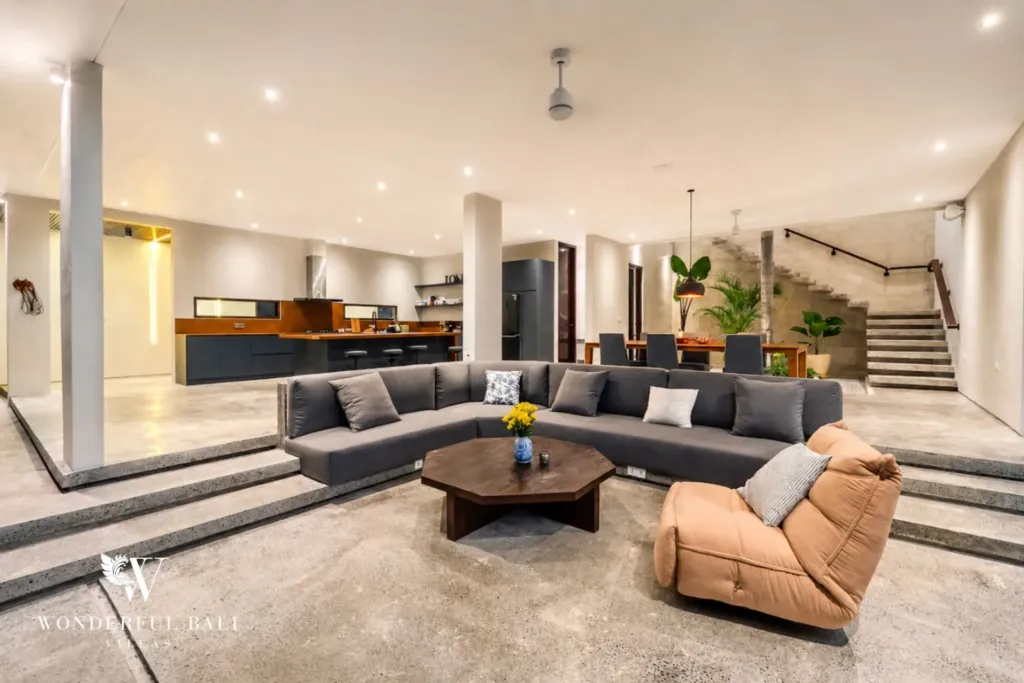 4BR villa for rent in Seminyak — living room, open-plan living with a large sectional and the staircase