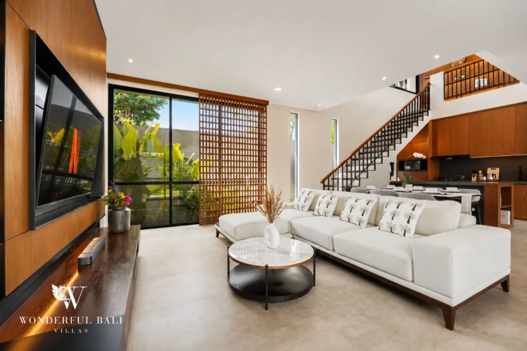 Living room with wall-mounted smart TV and stair behind in a 3-bedroom villa in Jimbaran Bali