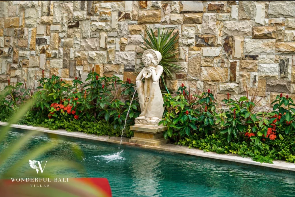 Carved stone fountain spilling into the pool at a 3-bedroom villa in Tumbak Bayuh Bali