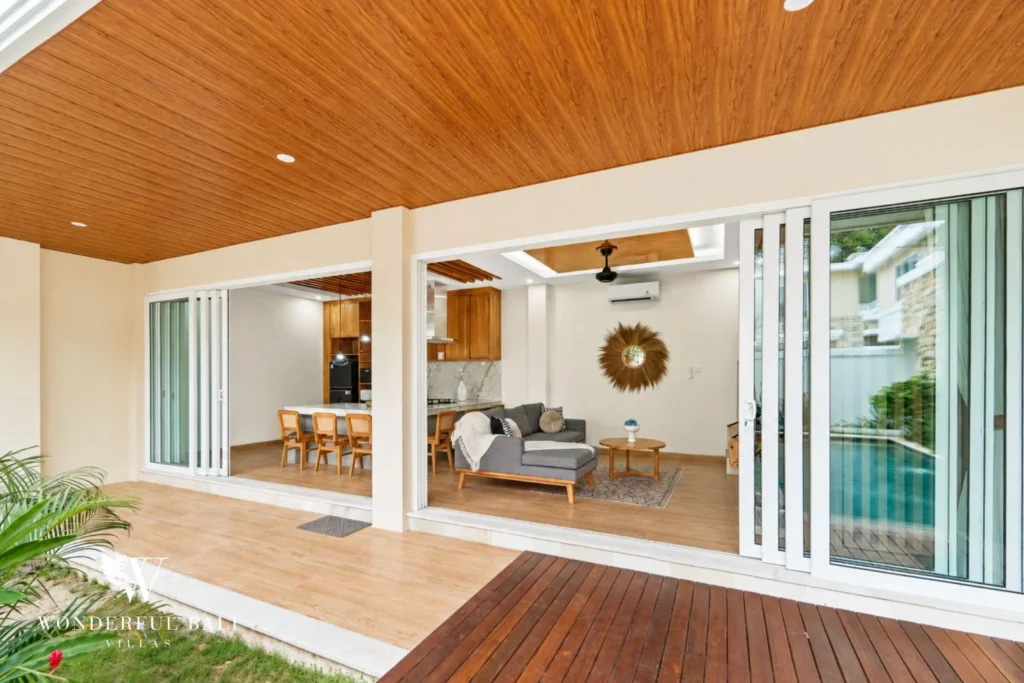 Covered terrace with timber ceiling opening to the living room in a 3-bedroom villa in Tumbak Bayuh Bali