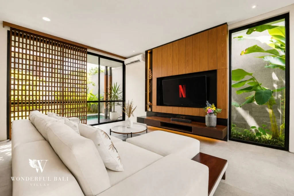 White sofa and TV wall framed by slatted screens in a 3-bedroom villa in Jimbaran Bali