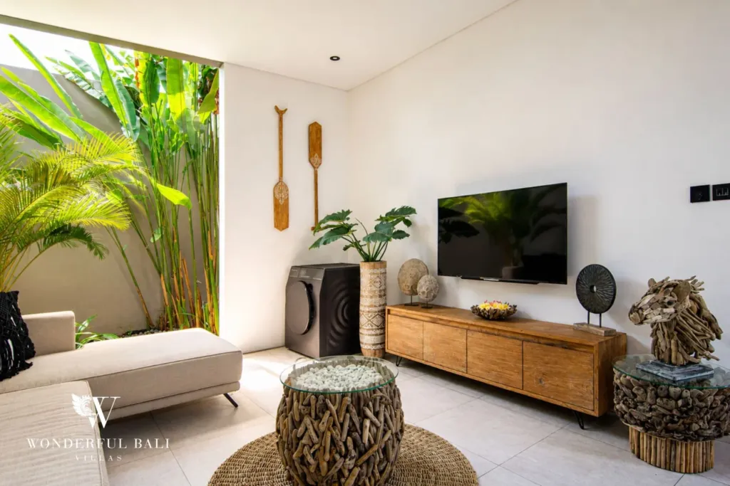 2BR villa for rent in Bumbak, Umalas — living room, a wall-mounted smart TV above a timber console and a washing machine