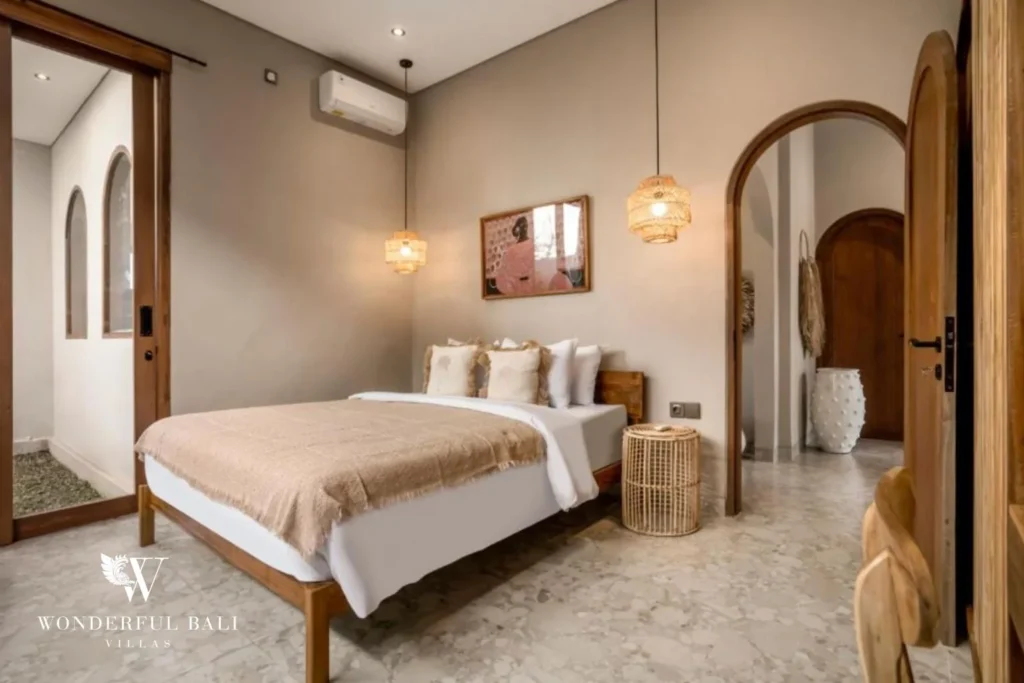 Bedroom with arched doorway and rattan pendants in a 2-bedroom villa in Pererenan Bali