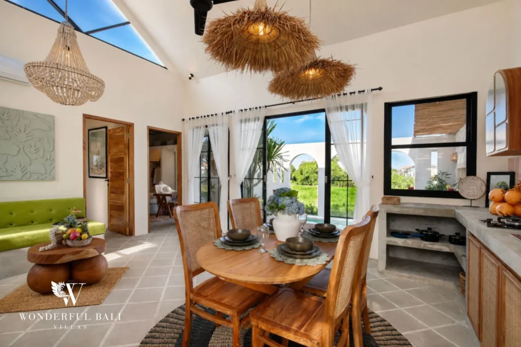 Dining table beside sliding doors onto the pool and rice fields in a 2-bedroom villa in Buduk Canggu Bali