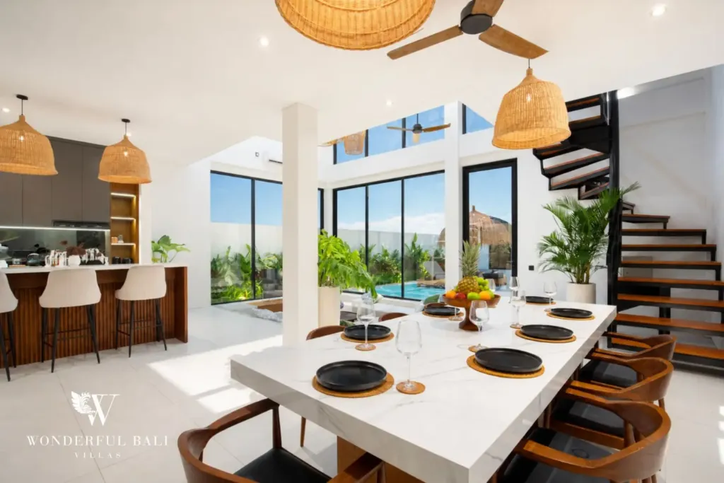 Dining table beside a kitchen breakfast bar at a 3BR villa in Pererenan Bali