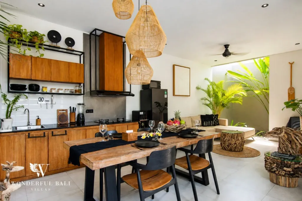 2BR villa for rent in Bumbak, Umalas — kitchen, timber kitchen with black stone worktop beside a live-edge dining table in a 2-bedroom villa