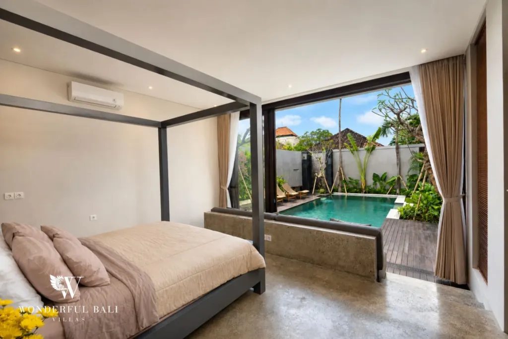 4BR villa for rent in Seminyak — bedroom, four-poster bed opening straight onto the pool