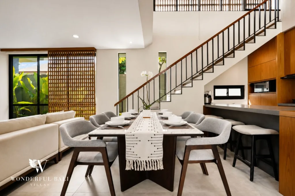 Dining table and kitchen breakfast bar below the stair in a 3-bedroom villa in Jimbaran Bali