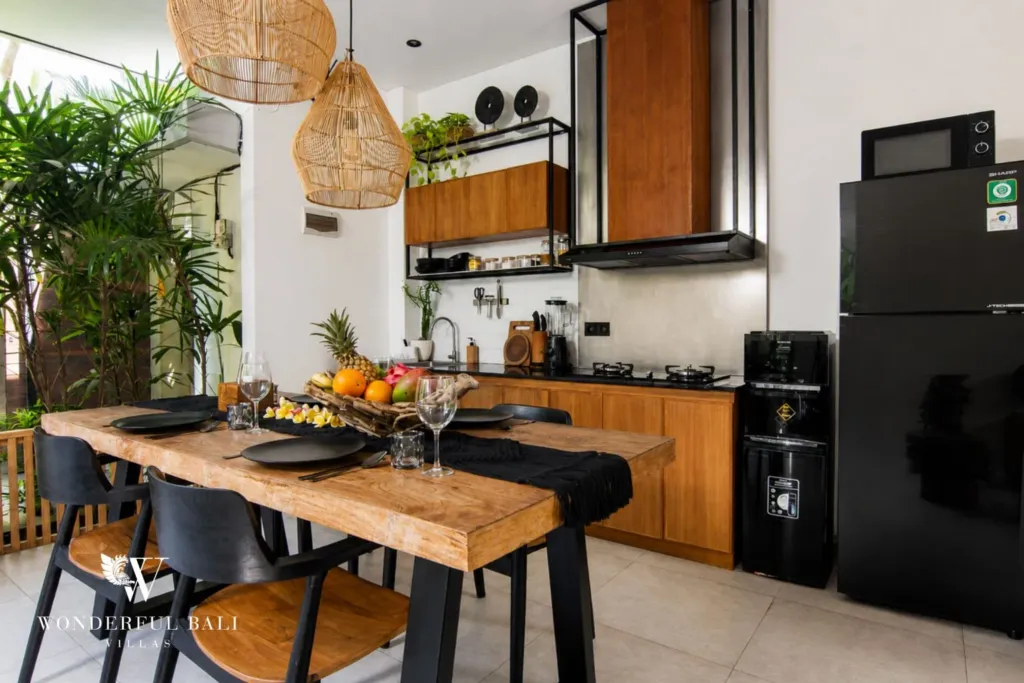 2BR villa for rent in Bumbak, Umalas — dining, live-edge dining table laid for four in front of the kitchen in a 2-bedroom villa